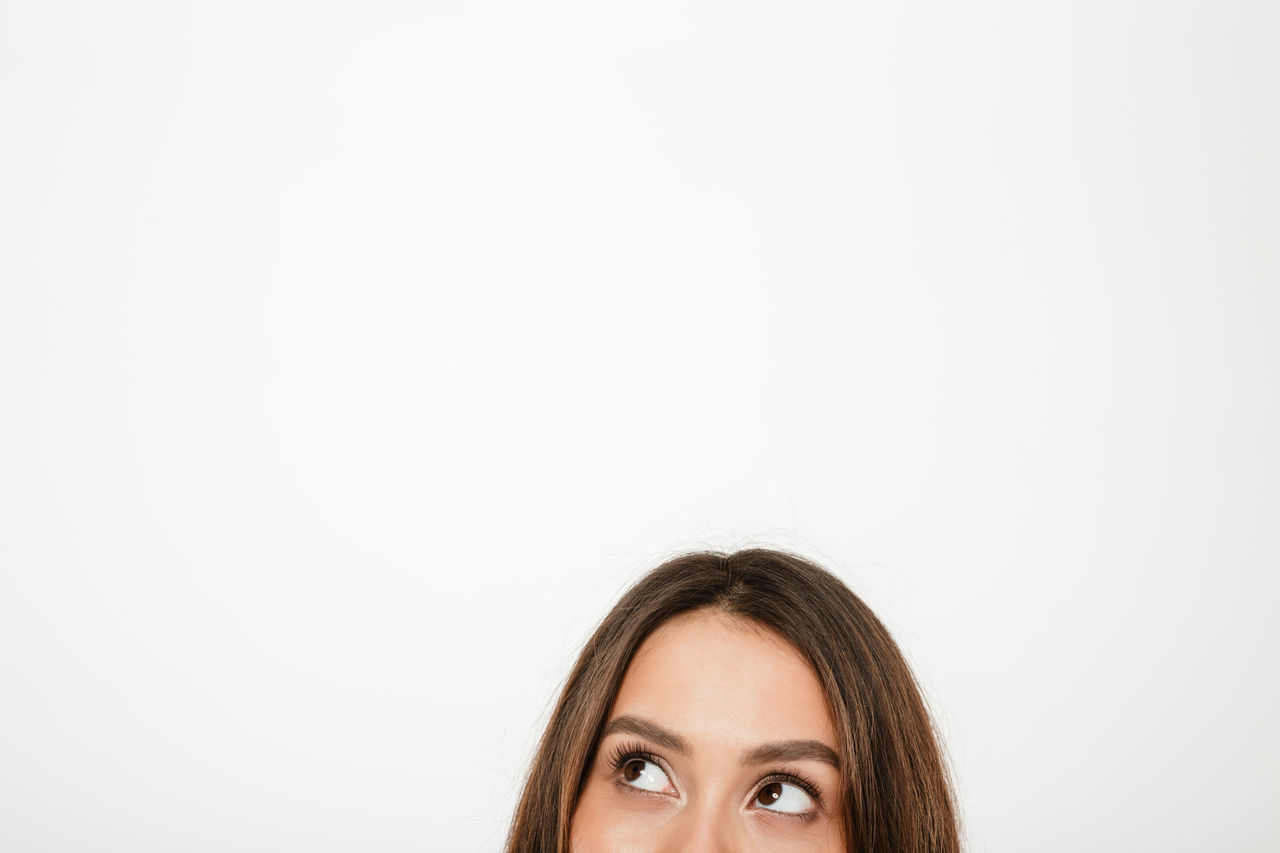 Half face of mystery brunette woman looking away over gray background, Half face of mystery brunette woman looking away over gray background