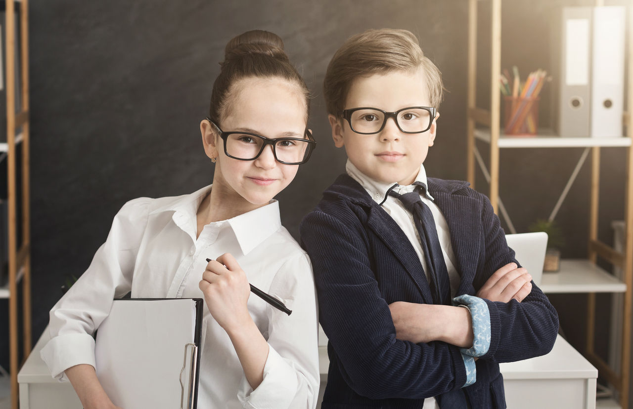 Family business. Cute boy and girl in formal wear working together as successful team, posing in office, copy space